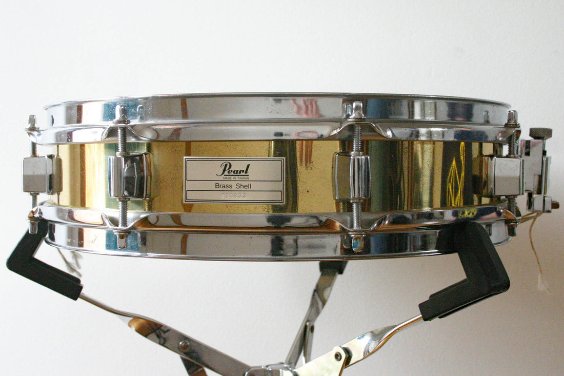 Pearl brass piccolo snare drum with new batter head.